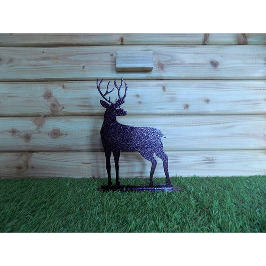 bronze reindeere with antlers on grass with wooden background