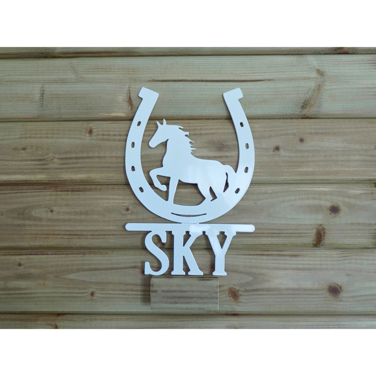Personalised horseshoe metal sign with trotting horse silhouette and name “SKY”, white powder-coated finish, handmade in Ireland