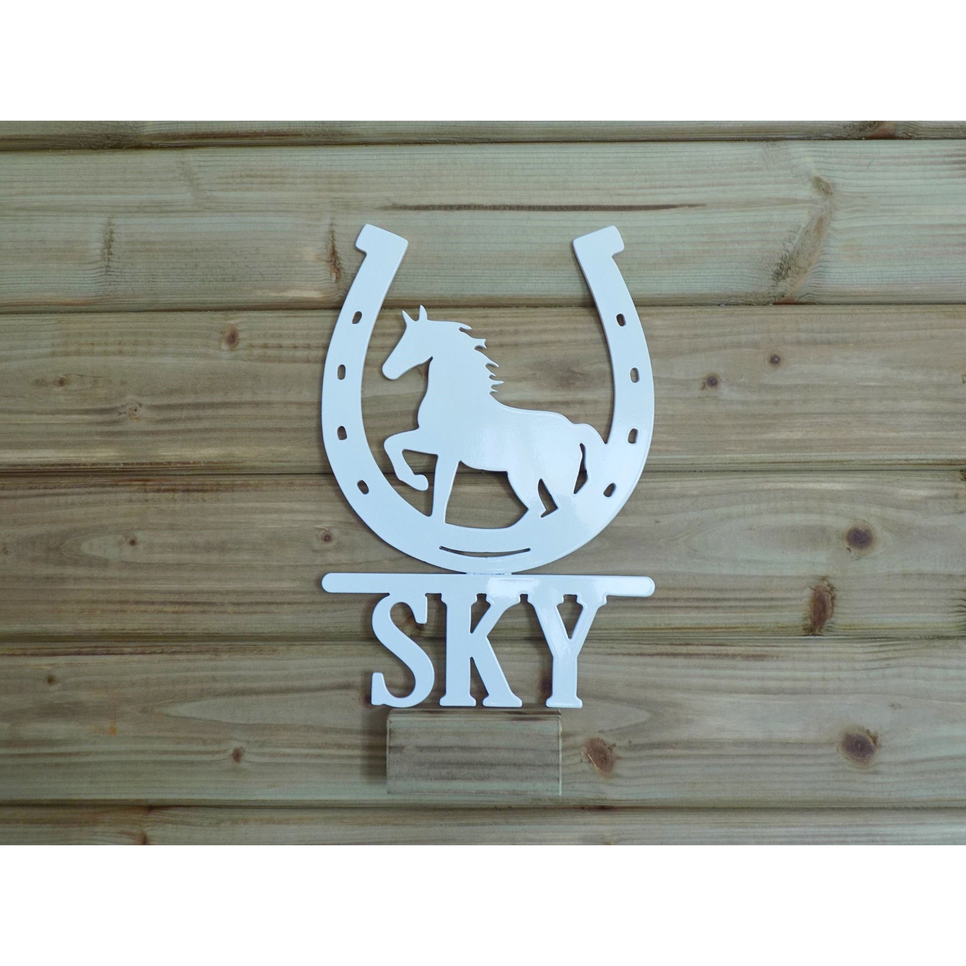 Personalised horseshoe metal sign with trotting horse silhouette and name “SKY”, white powder-coated finish, handmade in Ireland