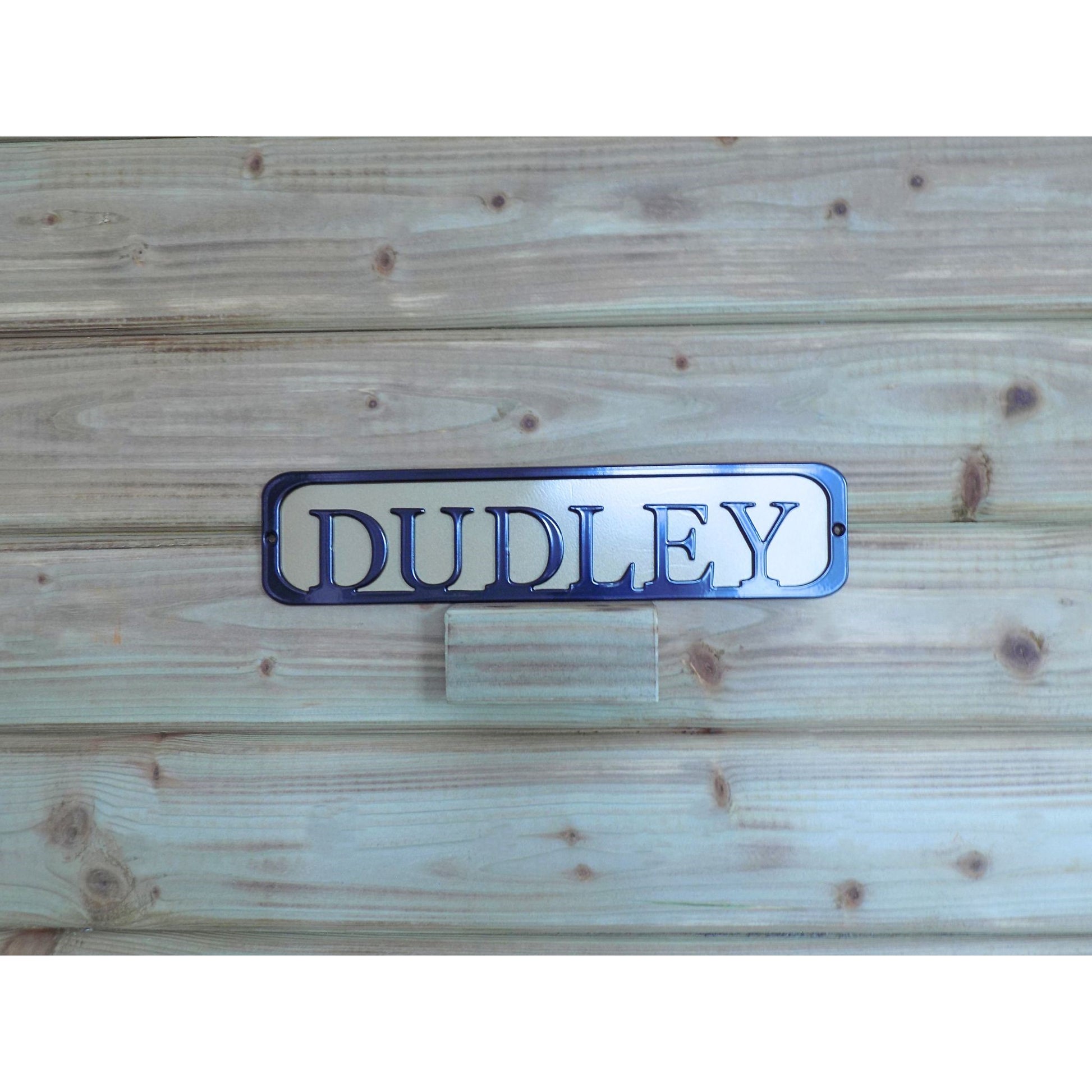 Metal sign with text 'DUDLEY' black on a Gold backing plate